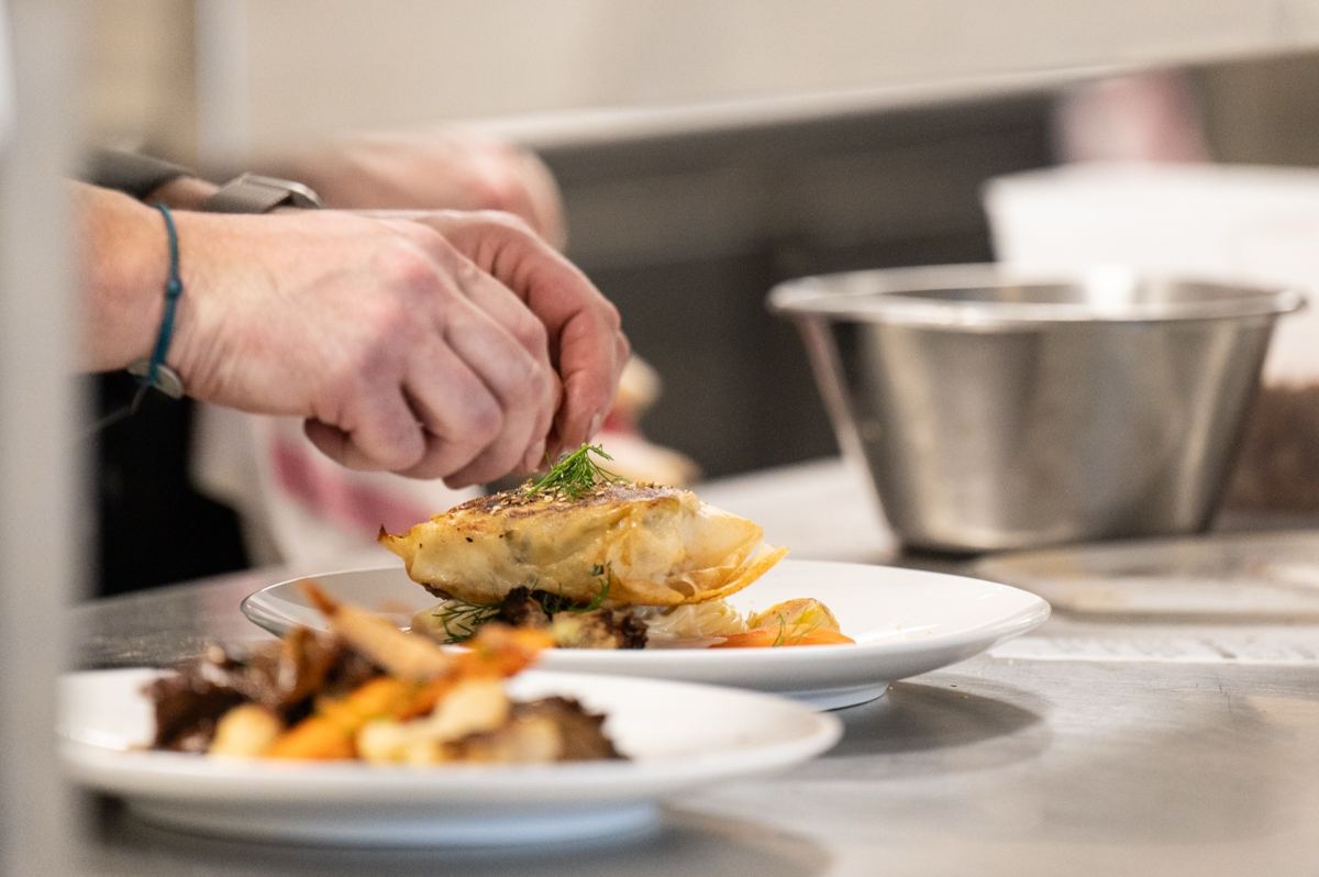 En cuisine, le chef dresse une assiette