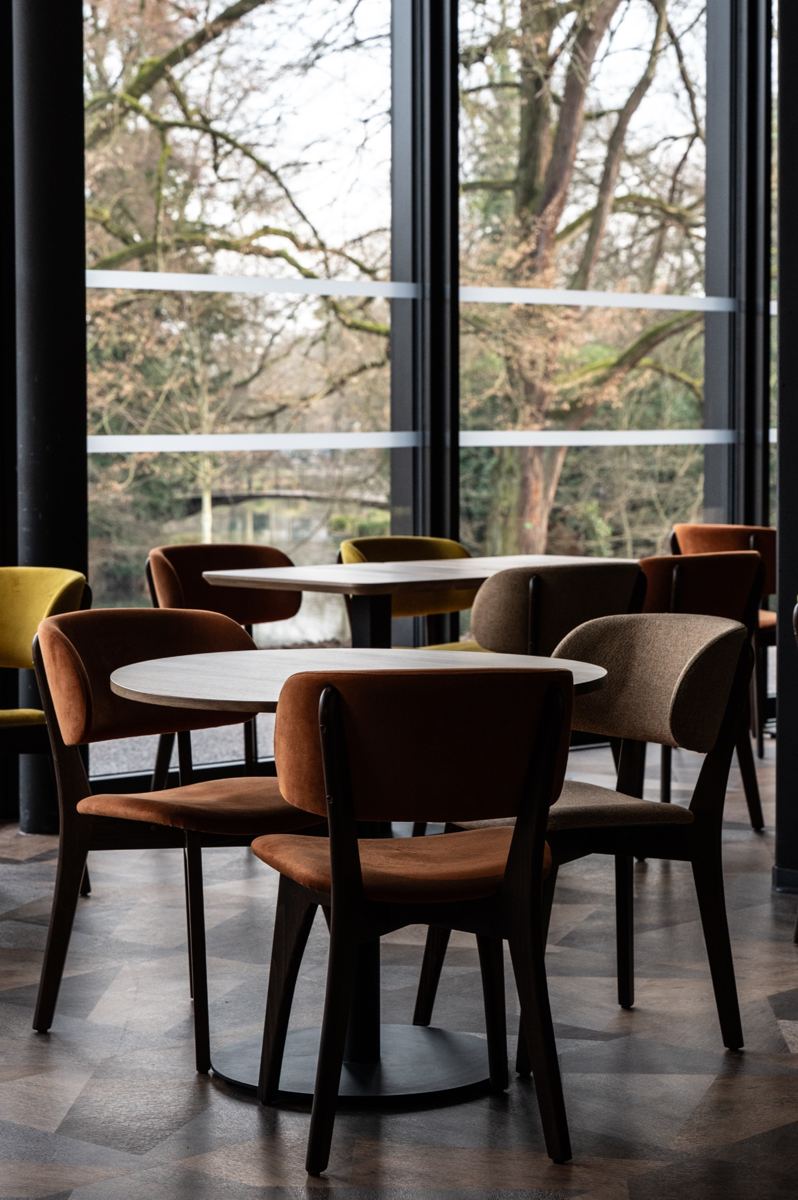 La salle du restaurant et ses baies vitrées ouvertes sur le parc